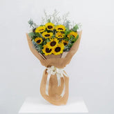 Sunflower bouquet with greenery wrapped in brown paper, ideal for flower delivery in Singapore
