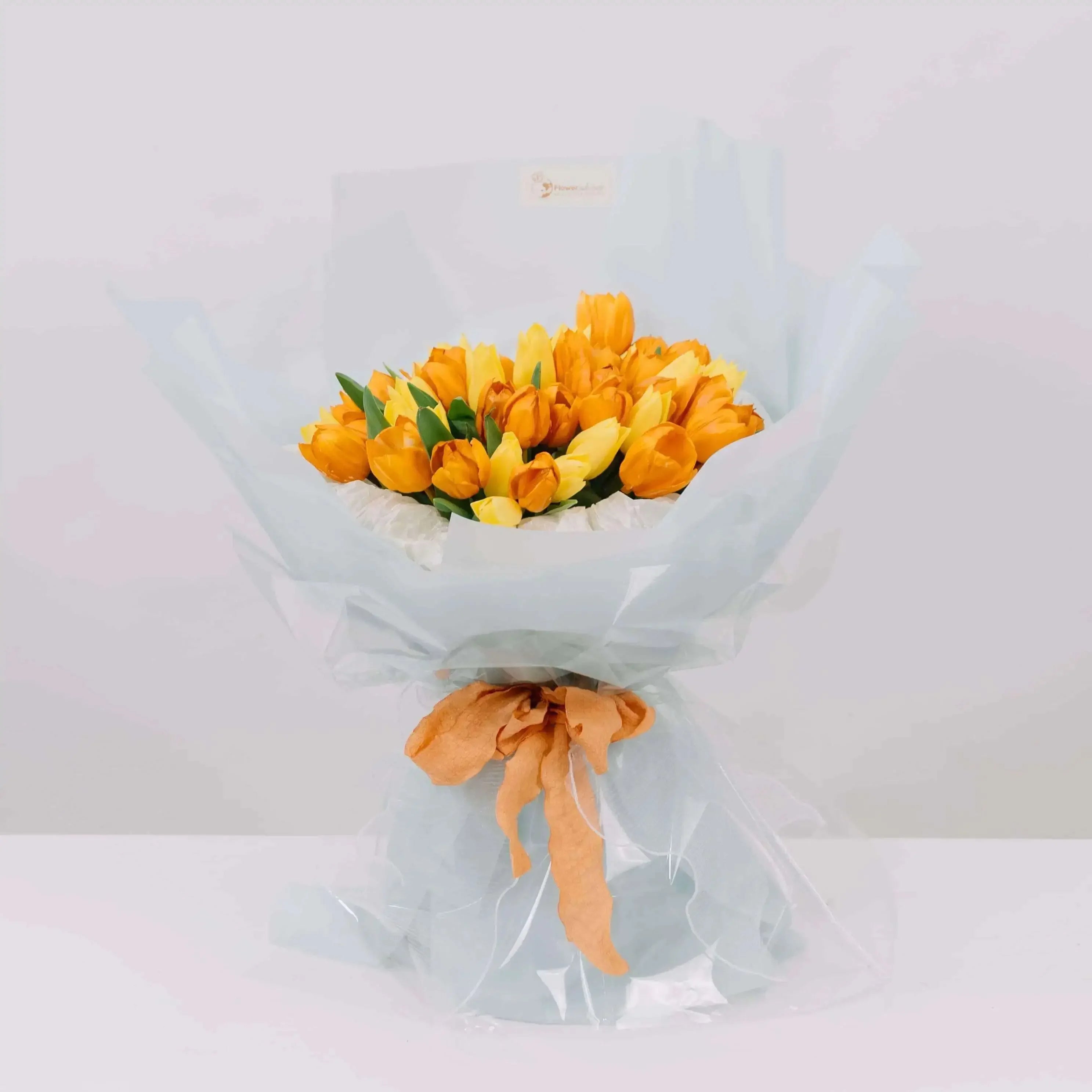 Bouquet of yellow and orange tulips wrapped for flower delivery