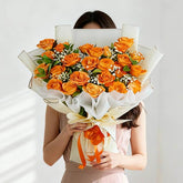 Hand delivering a large bouquet of fresh orange roses, ideal for flower delivery in Singapore