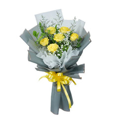 Yellow roses bouquet with baby's breath, wrapped in gray paper and tied with yellow ribbon for flower delivery