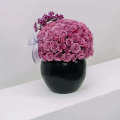 Purple rose bouquet and mini orchid in black vase for flower delivery