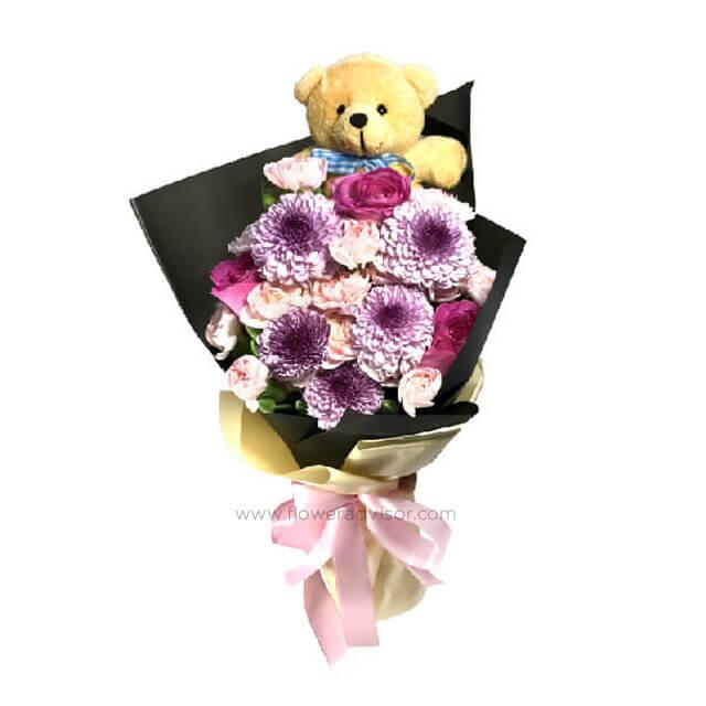Purple rose and pink carnation bouquet with a teddy bear for flower delivery