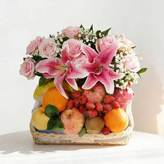 Flower delivery basket with pink lilies, roses, and assorted fresh fruits