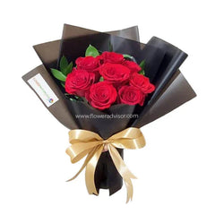 Hand bouquet of 8 red roses with greens for flower delivery, wrapped in black paper with gold ribbon