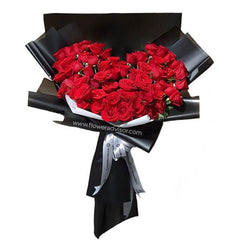 Heart-shaped bouquet of 60 red roses in black wrapping for flower delivery