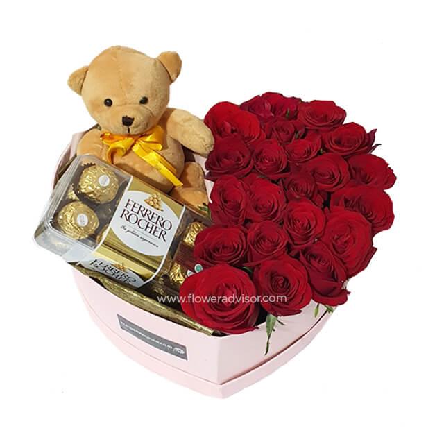 Heart-shaped box with red roses, Ferrero Rocher chocolates, and a teddy bear for flower delivery