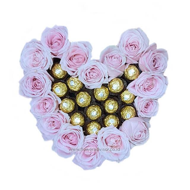 Heart-shaped box with pink roses and gold chocolates, perfect for flower delivery