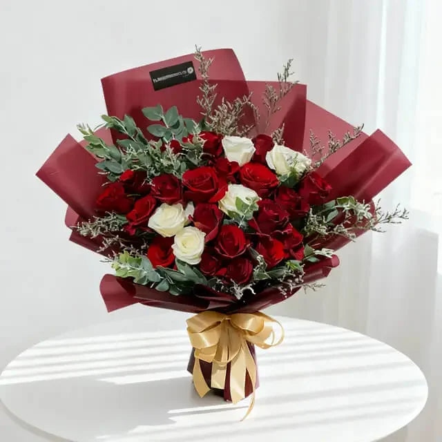 Red and white roses bouquet with gold ribbon, perfect for flower delivery in Singapore