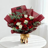 Red and white roses bouquet with gold ribbon, perfect for flower delivery in Singapore