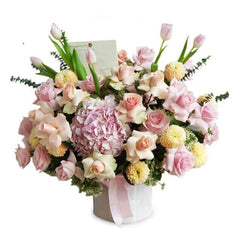 Mixed flower arrangement with pink roses, hydrangeas, and tulips in a vase for delivery