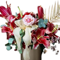 Elegant floral arrangement with red lilies, pink rose, and white ribbon for flower delivery