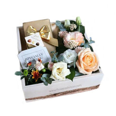 Peach-themed flower arrangement in a gift box with flowers and chocolates for delivery