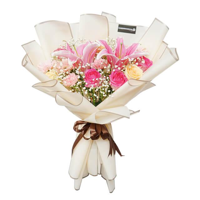 Elegant hand bouquet with pink lilies, roses, and baby's breath for flower delivery