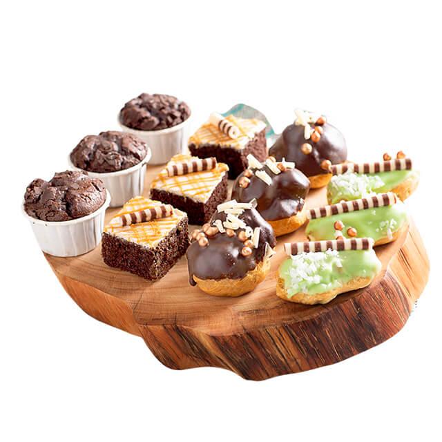 Assorted gourmet cupcakes and pastries on wooden tray, ideal gift with flower delivery Singapore