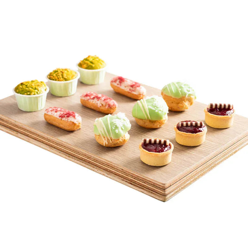Assorted flower-inspired pastries and desserts on a wooden tray, perfect for gift delivery
