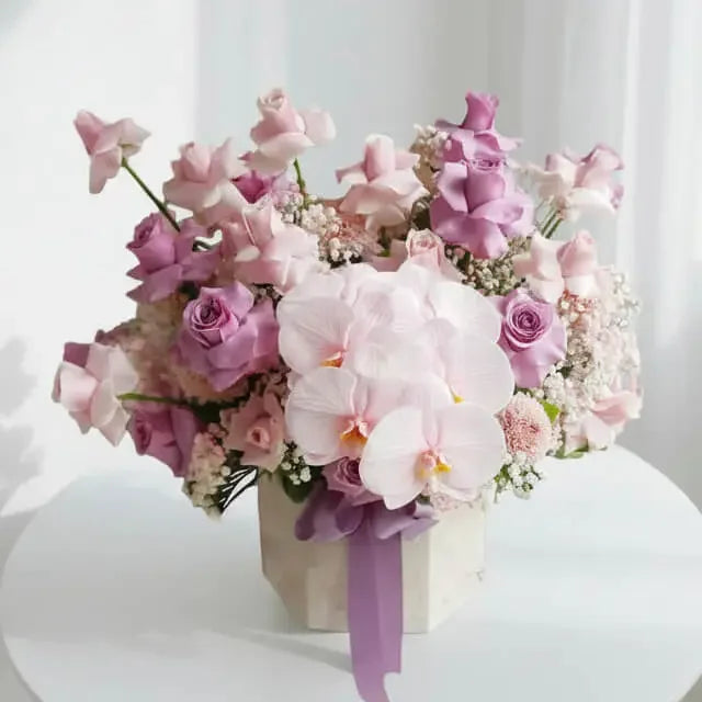 Elegant pink and purple bloom box with roses and orchids for flower delivery