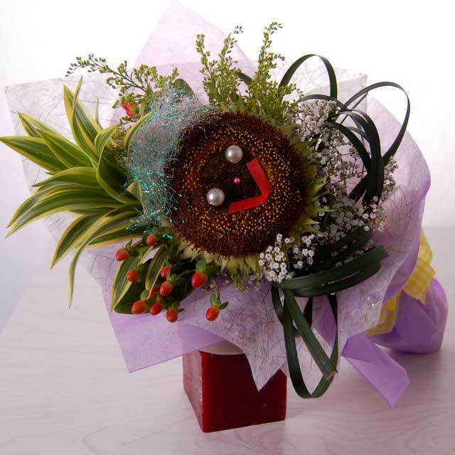 Unique sunflower bouquet with smiley face, greenery, and berries for flower delivery