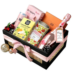 Luxury flower delivery hamper with pink sparkling wine, gourmet snacks and festive decor.
