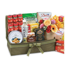 Flower delivery hamper with fresh bouquet, assorted snacks, and gift items in a box