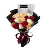 Mixed rose bouquet for flower delivery, featuring red, white, and peach roses in black wrap