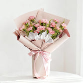 Pink carnation bouquet with greenery and soft wrapping, perfect for flower delivery