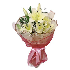 Elegant bouquet of fresh white lilies and greenery wrapped for flower delivery