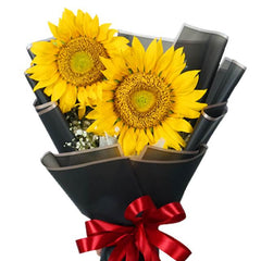 Sunflower bouquet with black wrapping and red ribbon for flower delivery
