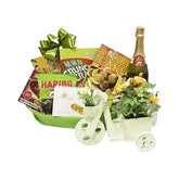 Flower delivery gift hamper with fresh flowers, gourmet snacks, and treats in a green basket