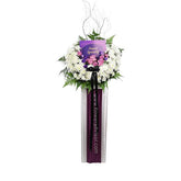 Sympathy flower stand with white chrysanthemums, purple roses, and greenery for delivery