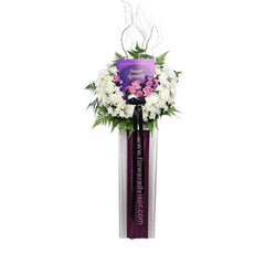 Sympathy flower stand with white chrysanthemums, purple roses, and greenery for delivery