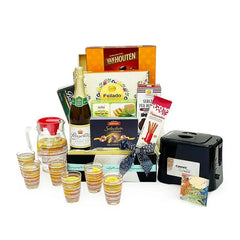 Festive hamper with assorted treats, pitcher, glasses, and snacks for gift and flower delivery.