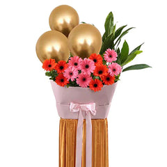 Grand opening flower stand with pink and red gerbera daisies, gold balloons, and greenery for delivery