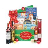 Festive gourmet Christmas hamper with cookies, chocolates, wine and a Merry Christmas sign, perfect for gift and flower delivery.