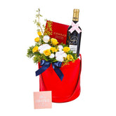 Festive flower delivery gift hamper with yellow roses, wine bottle, and holiday card