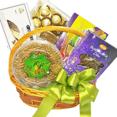 Gift hamper with dates, chocolates, cookies, and treats in a basket with green ribbon, ideal for flower delivery gifts
