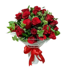 Red rose bouquet with greenery, white wrapping, and red ribbon for flower delivery