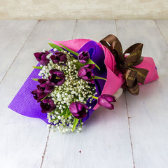 Purple tulip bouquet with baby's breath for flower delivery, wrapped in pink and purple.