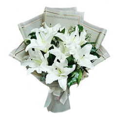 Elegant white lily bouquet for flower delivery, wrapped in cream paper with greenery