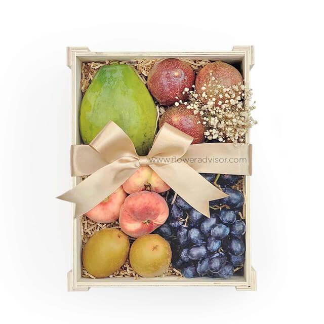 Flower delivery gift box with fresh fruits and small bouquet, ribbon wrapped.