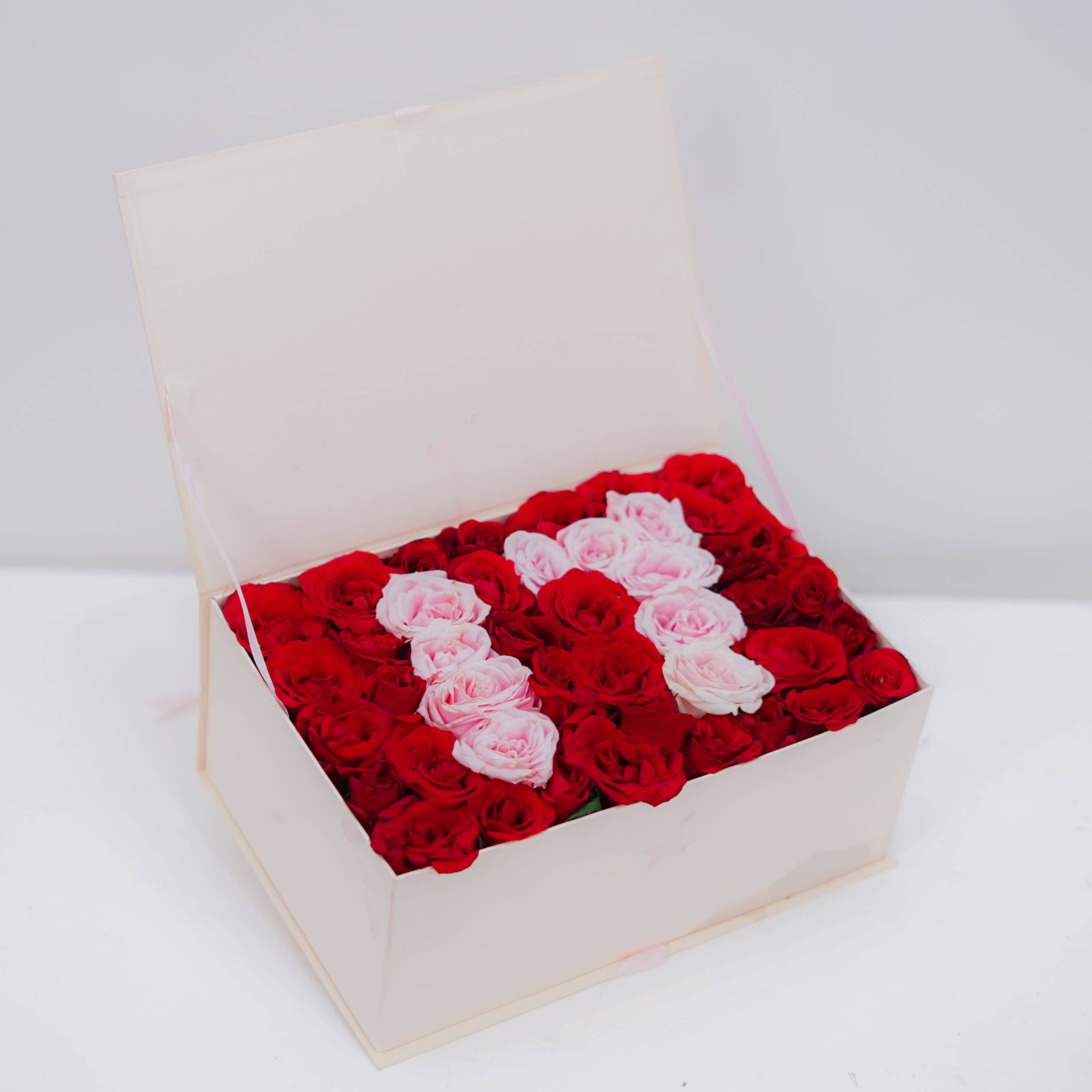 Flower delivery box with red and pink roses arranged in the shape of the number 11