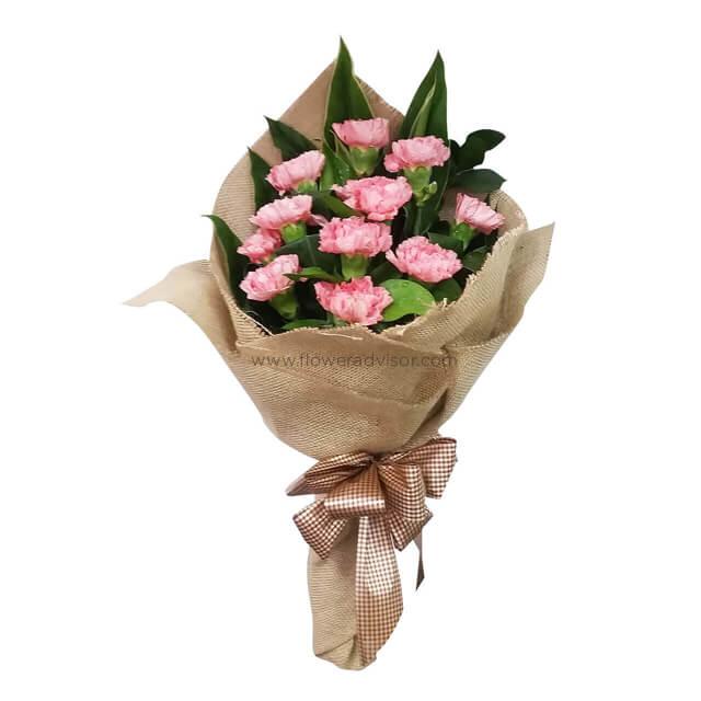 Bouquet of 12 pink carnations in rustic wrapping for flower delivery in Singapore