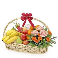 Flower and fruit basket with pink carnations, orange roses, and fresh fruits for flower delivery