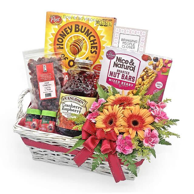 Flower delivery basket with mixed fresh flowers, snacks, juice and gift items