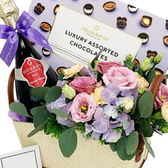 Flower delivery gift basket with pastel flowers, champagne, and luxury assorted chocolates