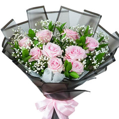Pink rose bouquet with baby’s breath, wrapped in black for flower delivery