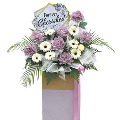 Condolence flower stand with purple carnations and white gerberas for flower delivery