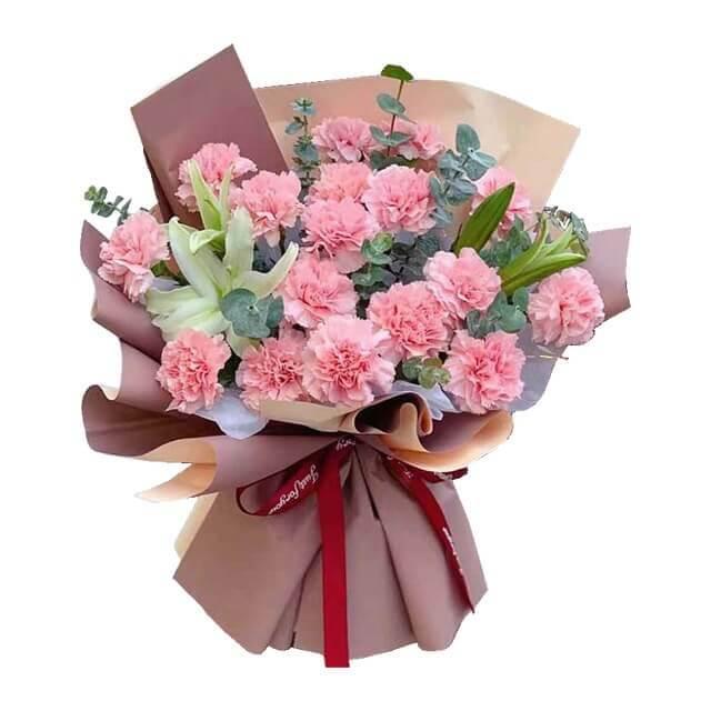 Pink carnation bouquet with lilies and greenery, wrapped for flower delivery in Singapore