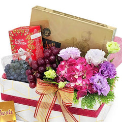 Fresh flower delivery gift hamper with grapes, tea, snacks, and a floral bouquet
