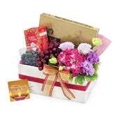 Flower delivery gift hamper with fresh flowers, grapes, tea, festive card and ribbon