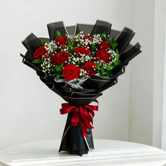 Elegant red rose bouquet with baby’s breath in black wrapping for flower delivery